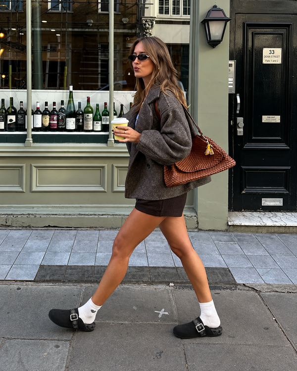 Black Ashton clogs styled with white socks, shorts, and a brown jacket