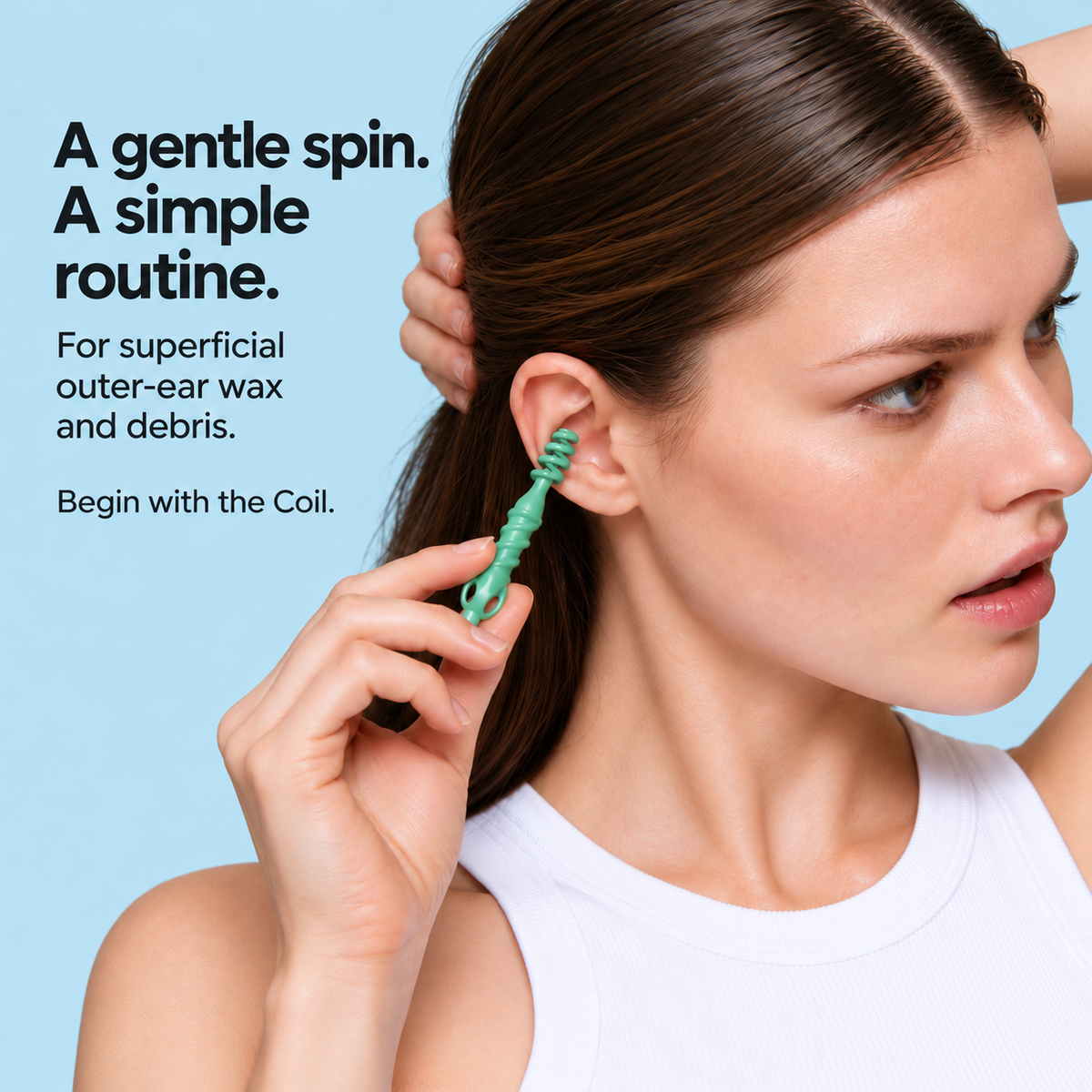 Woman demonstrating the green Coil at the accessible outer ear.